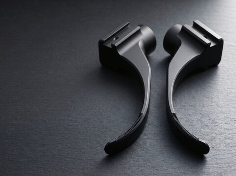 Macro product photograph of matte black radiolucent titanium spinal micro retractor blade pair with serrated distal edge for minimally invasive spine tubular decompression surgical procedure