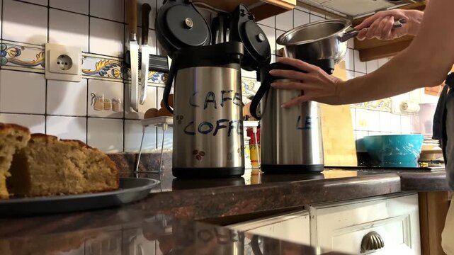 Mujer vertiendo leche caliente de un cazo a un termo