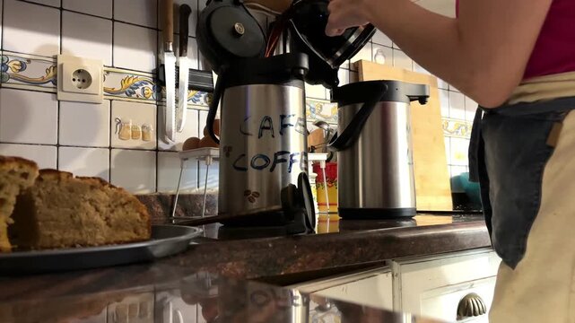 Mujer vertiendo caf&eacute; de una cafetera a un termo