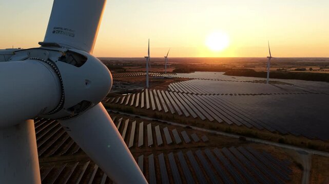 Wind Turbine Rotor Hub Nose Cone and Solar Farm at Golden Sunset Aerial View UK