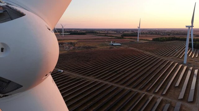 Wind Turbine Rotor Hub Nose Cone and Solar Farm at Golden Sunset Aerial View UK