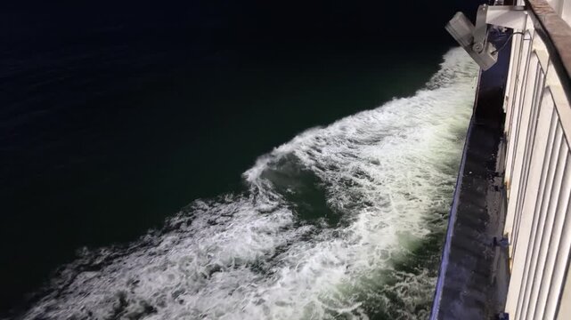 Night view of sea from ship side, waves near hull