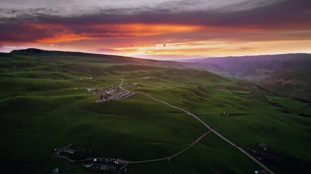 Aerial View of Rural Settlement in Rolling Green Hills at Sunset