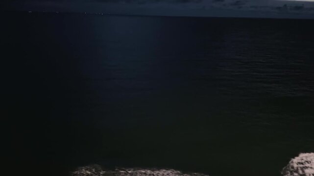 Night view of sea surface with waves near ship hull 
