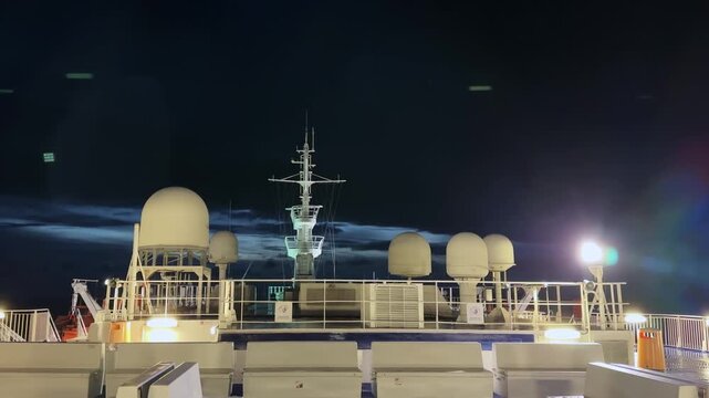 Cruiseferry upper deck with mast and other equipment at night