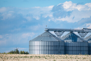 Detail of modern grain silos and storage facility on farmland with beautiful cloudy sky © Cristi