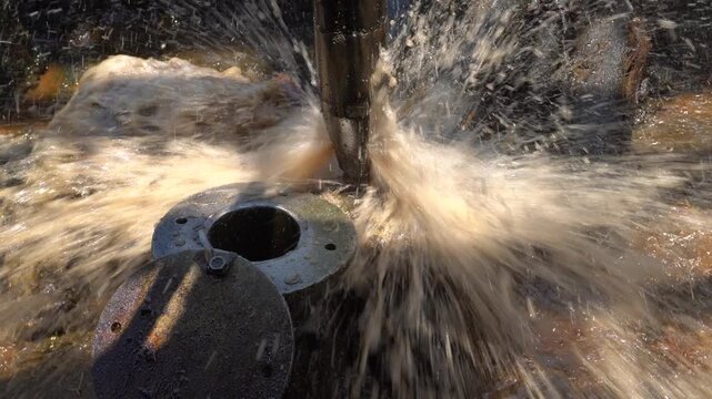Long bailer pipe extracting crude oil with dynamic spray at Wonocolo traditional well, Bojonegoro, East Java, Indonesia. Historic artisanal petroleum bailing process and heritage energy mining.