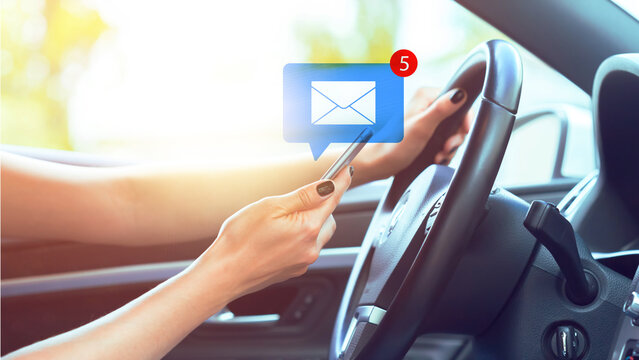 Driver receives messages while holding a smartphone and steering wheel in a car