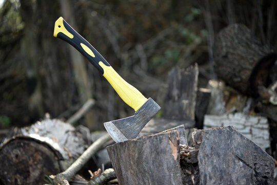 an axe in a stump. axe embedded in a wooden log, evoking notions of forestry, craftsmanship, and outdoor activities in nature. preparing firewood for the winter. work in the village. active lifestyle