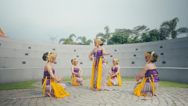 Group of Dancers Sitting in Circle on Paved Ground Outdoors