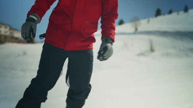 A person in a red jacket snowboards down a snowy mountain. This dynamic video captures a popular winter sport.