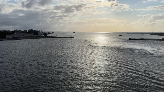 Seaport with berths and port cranes from moving vessel
