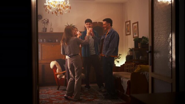 Diverse young friends enjoying music and dancing at home apartment party