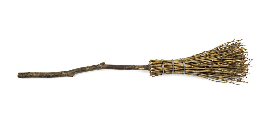 Rustic primitive broom made of tied twigs and wooden handle on white background.
