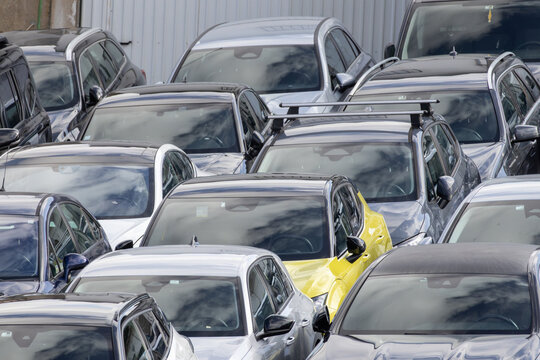 Many cars parked in a crowded urban parking lot