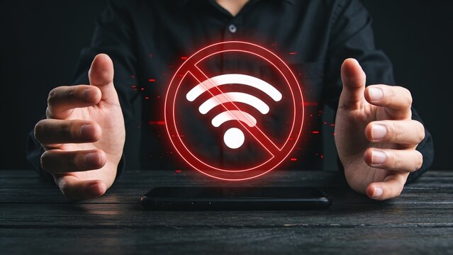 Hands presenting glowing red holographic no wifi symbol on dark background