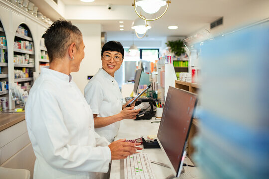 Two pharmacists collaborating at modern retail pharmacy counter