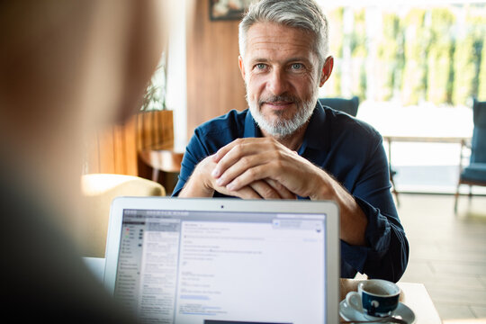 Mature businessman meeting with colleague in cafe