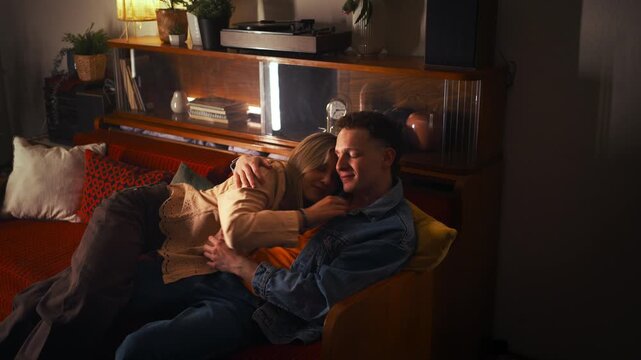 Young couple relaxing together and chilling in cozy living room night