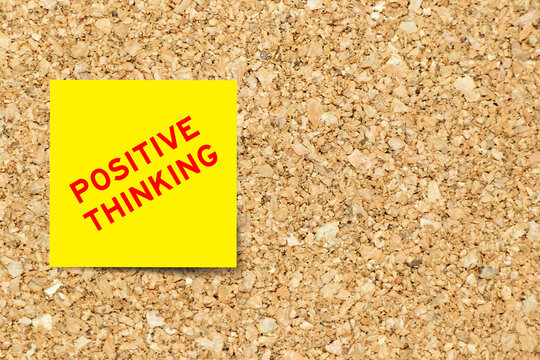 Yellow note paper with word positive thinking on cork board background with copy space
