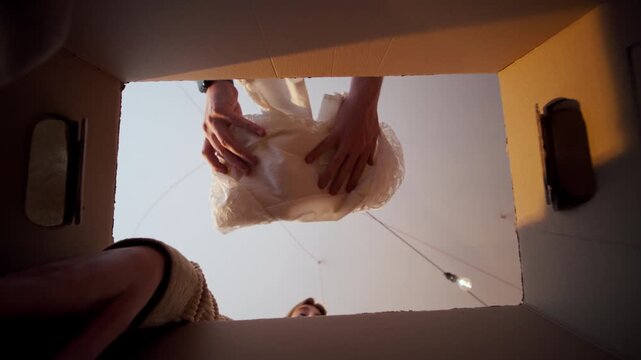 People looking into a cardboard box