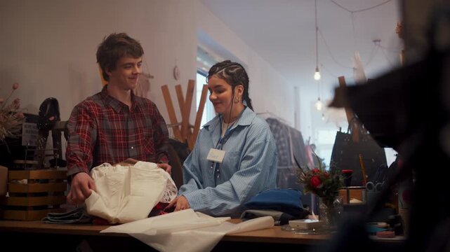 Dynamic Team Of Fashion Designer And Assistant Preparing Prototypes In Lively Studio Environment