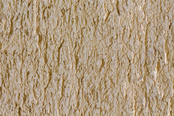 Fototapeta premium Close-up textured background of a rough, sandy beige stucco wall surface