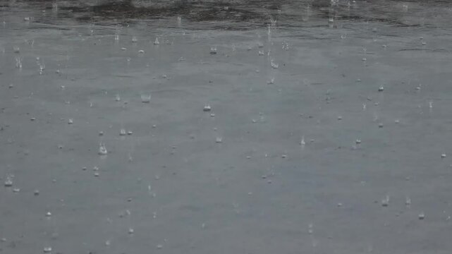 Heavy Rain Splashing on a Grey Water Surface