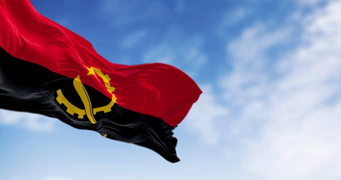 Close-up of Angola national flag waving in the wind on a clear day
