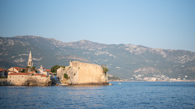 Historic stone fortress and coastal old town of Budva, Montenegro, border the calm blue Adriatic Sea