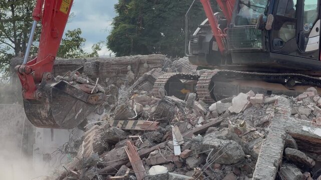 excavator demolishing a building and clearing rubble