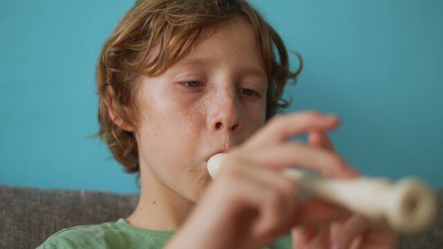 A little boy learns to play the flute at home, practicing with focus and enthusiasm in a cozy, warm setting. A charming scene of early musical exploration, creativity, and childhood growth.