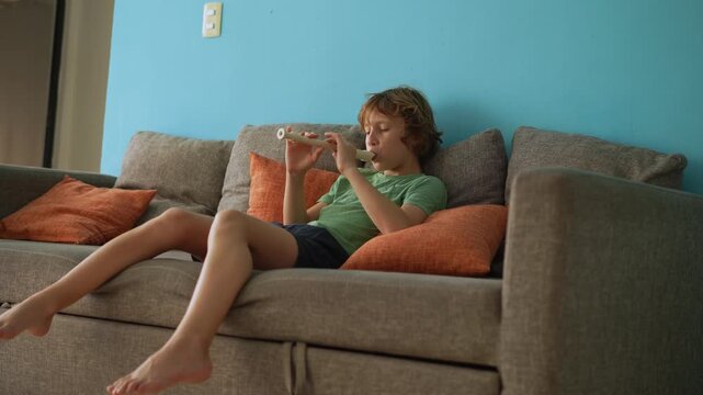 A little boy learns to play the flute at home, practicing with focus and enthusiasm in a cozy, warm setting. A charming scene of early musical exploration, creativity, and childhood growth.