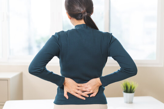 Body muscles hurt stiff, suffering asian young woman, girl back pain, body ache while stand up from desk at work, holding massaging rubbing back, problem health care of office syndrome people concept.