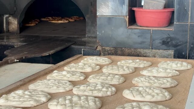 Fresh flatbreads baking in a traditional stone oven. Turkish pide. Turkish pide during Ramadan. 4K video.