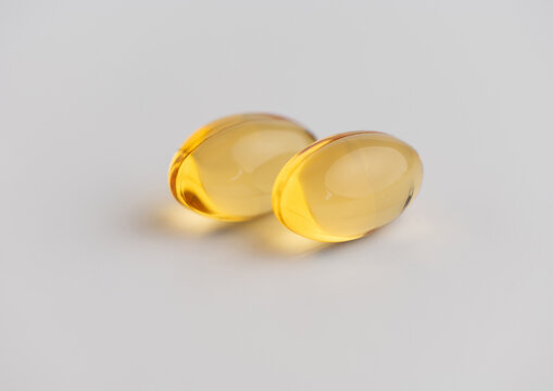 Two yellow fish oil soft gel capsules for health and nutrition dietary supplement