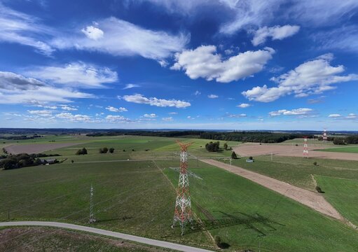 vue a&eacute;rienne panoramique des &eacute;oliennes et des pyl&ocirc;nes &agrave; haute tension &eacute;lectrique qui produisent et  transportent l'&eacute;nergie dans la r&eacute;gion de Bastogne, en Belgique, pr&egrave;s du village de Sibret. 
