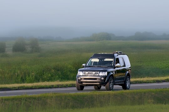 SUV crossing peaceful countryside road in motion