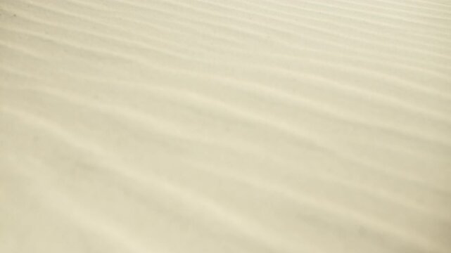 Waving clear water creating a caustic ripple sunlight pattern on the shallow sandy bottom of a swimming pool