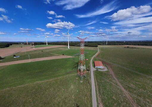 vue a&eacute;rienne panoramique des &eacute;oliennes et des pyl&ocirc;nes &agrave; haute tension &eacute;lectrique qui produisent et  transportent l'&eacute;nergie dans la r&eacute;gion de Bastogne, en Belgique, pr&egrave;s du village de Sibret. 