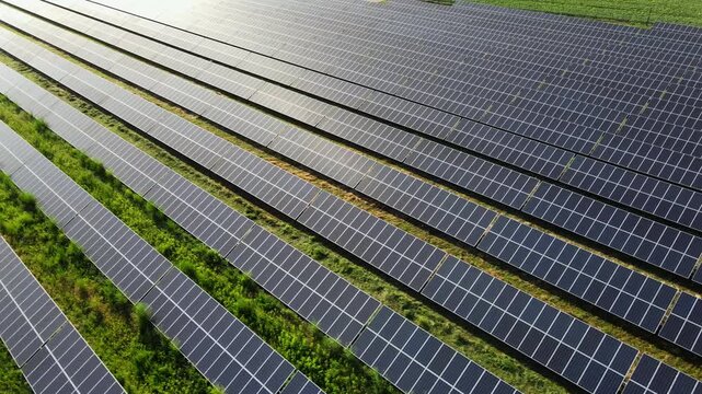 Aerial view of a solar farm generating renewable green energy from sunlight in a rural field