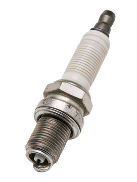 A close up view of a used metal spark plug with a white ceramic insulator showing signs of wear from internal combustion engine operation