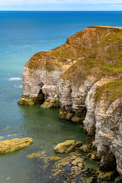 Dramatic chalk cliffs with sea caves, rock formations and turquoise water at Flamborough Head on the East Yorkshire coast of England in summer.