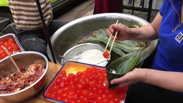 Handmade Cantonese zongzi wrapped with fresh bamboo leaves, stuffed with glutinous rice, pork belly and salted egg yolk. It is classic festive food for Dragon Boat Festival in southern China 2025‑9‑1