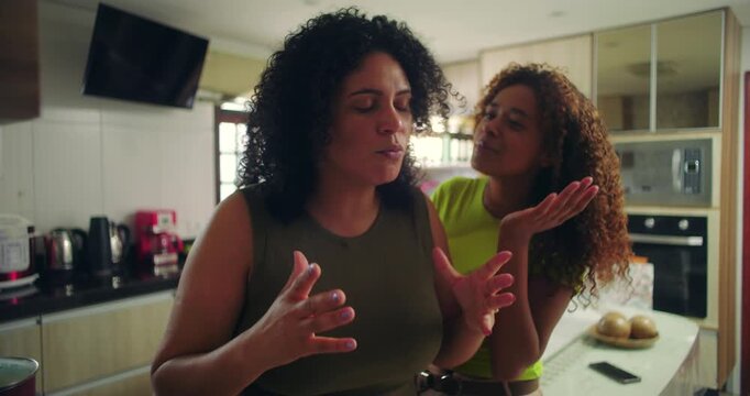 Mother overwhelmed by family demands, teenage daughter persistently asking for attention, dramatic moment highlighting parenting struggles and emotional stress, family of African descent