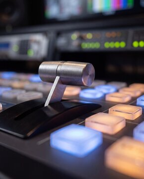 Macro view of metal T-bar fader on broadcast video switcher console