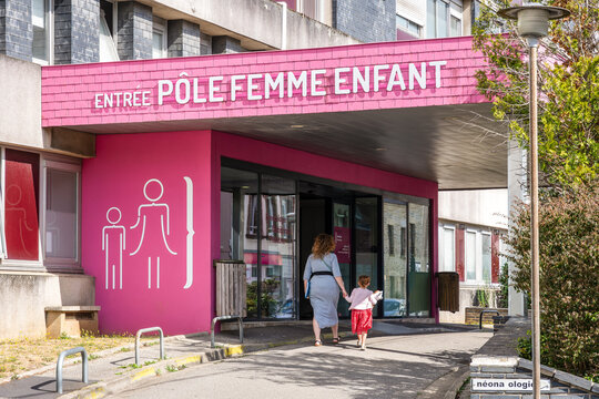 Cherbourg, France - July 20, 2026: A mother and daughter walk toward the entrance of the women's and children's department at the Louis Pasteur Hospital, part of the Cotentin Public Hospital Center.