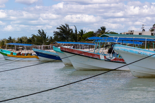 Colourful fishing boats with sun canopies moored in the shallow water on a tropical beach, Celestun, Yucatan Peninsula, Mexico