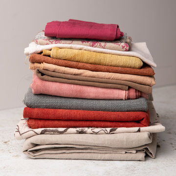 Close-up of a stack of folded colourful fabric samples and textiles on a table