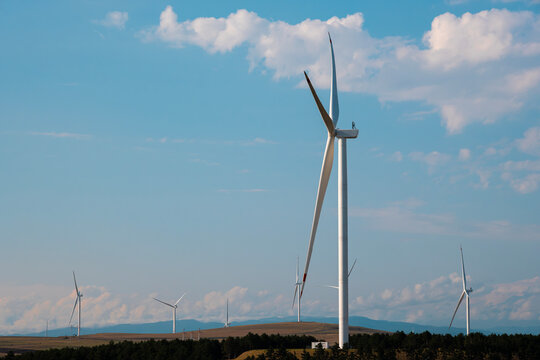 Wind turbines spinning, converting wind into sustainable electricity, a green power solution for a brighter future